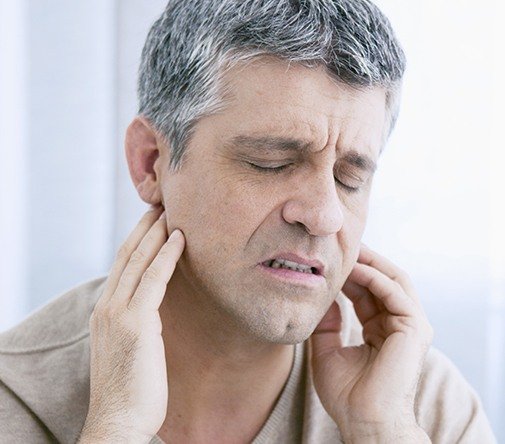 man with severe headache closing eyes