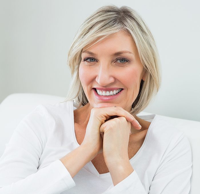 older woman smiling with head resting on fist