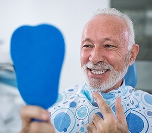 man checking smile in blue mirror