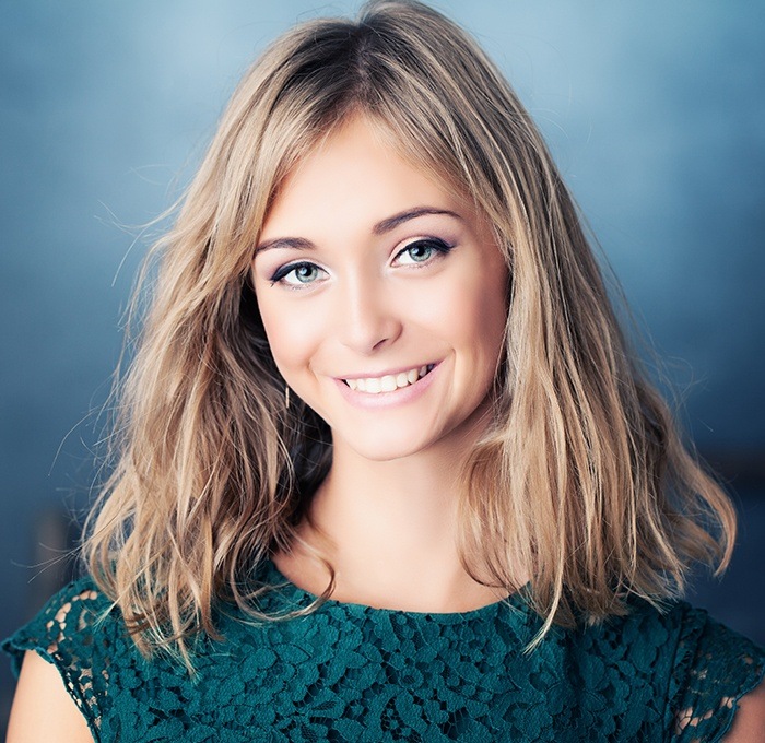 woman in blue lace top smiling