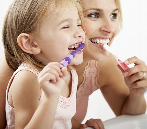 mother and daughter brushing teeth