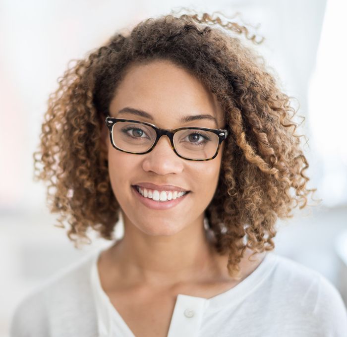 woman with glasses and curly hair smiling