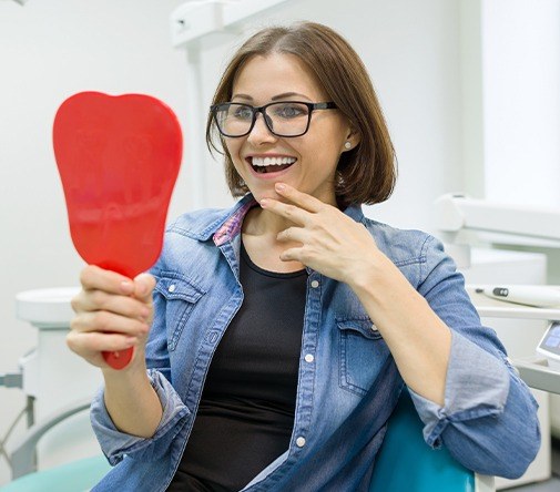 woman shocked checking smile in red mirror