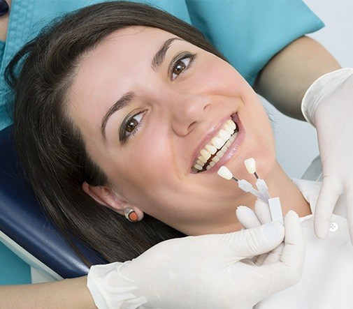 woman laying back being fitted for tooth shade