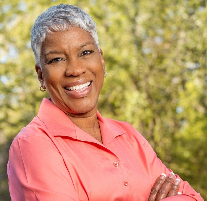 woman wearing coral shirt smiling