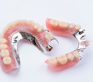 Two partial dentures arranged against neutral background