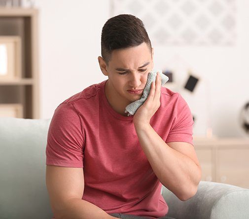 man holding rag on cheek