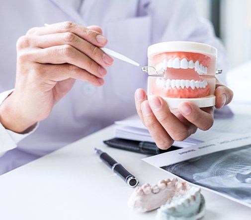 dentist using pin to point to mock up teeth