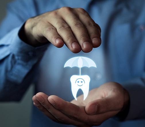 hands holding tooth with umbrella