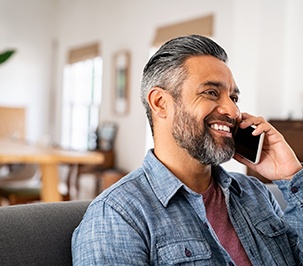 Man smiling while talking on phone