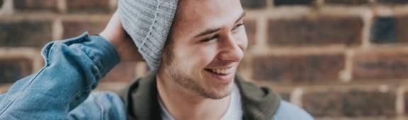 teen boy laughing with beanie on