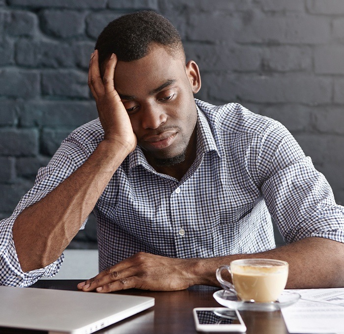 man tired with head on hand