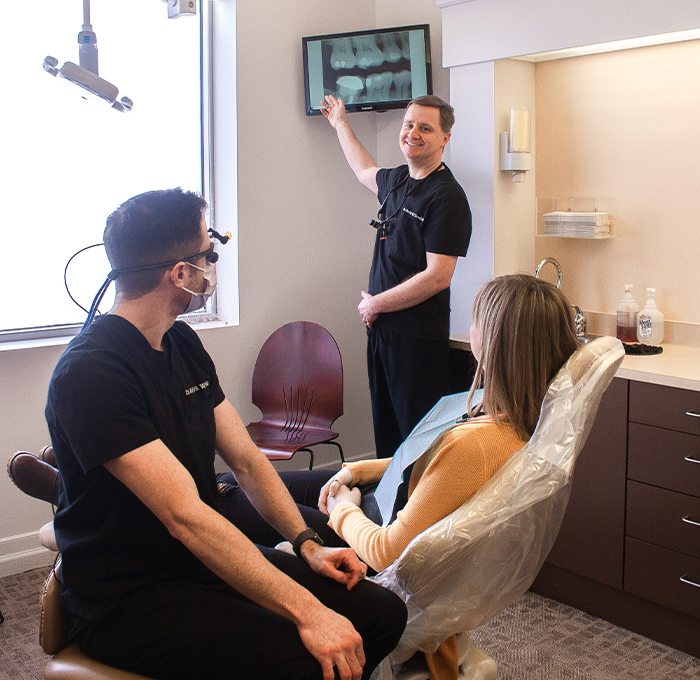 dentist pointing to x-ray on TV