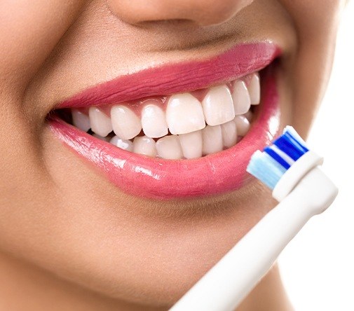 woman holding toothbrush in front of smile
