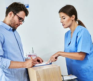 A male patient paying the cost of teeth whitening