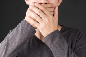 man covering mouth