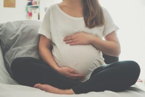 Pregnant woman sitting cross-legged
