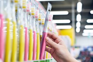 person taking a toothbrush of a shelf