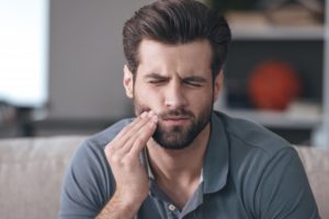 Pained man with toothache sitting at home during quarantine 