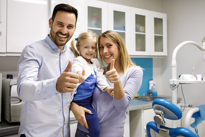 Family giving thumbs up after their dental checkup