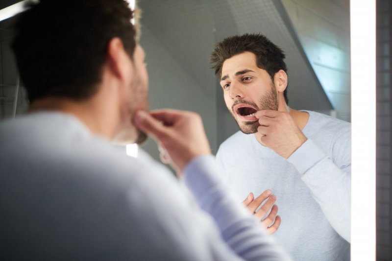 Man checking his teeth in a mirror