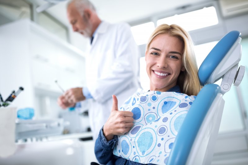 Woman smiling and giving thumbs up during appointment