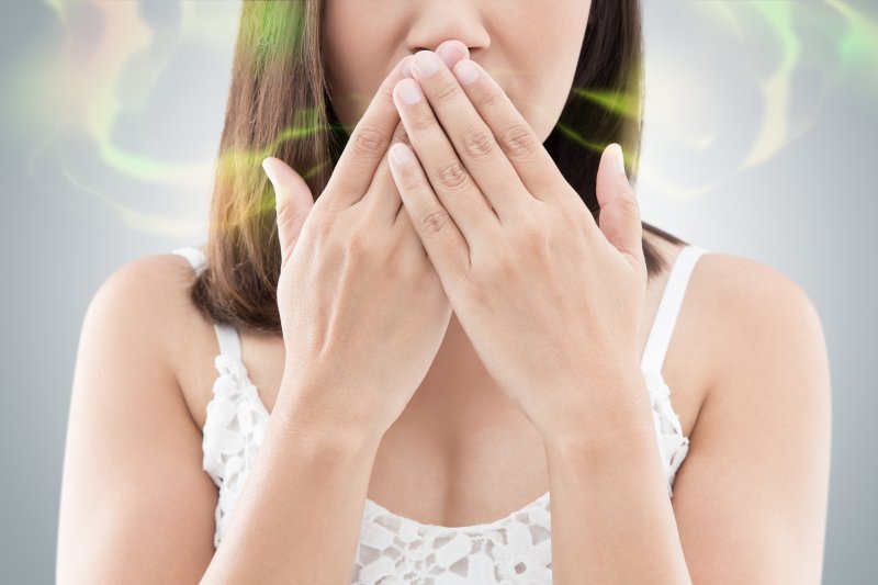 Woman covering her mouth to hide bad breath