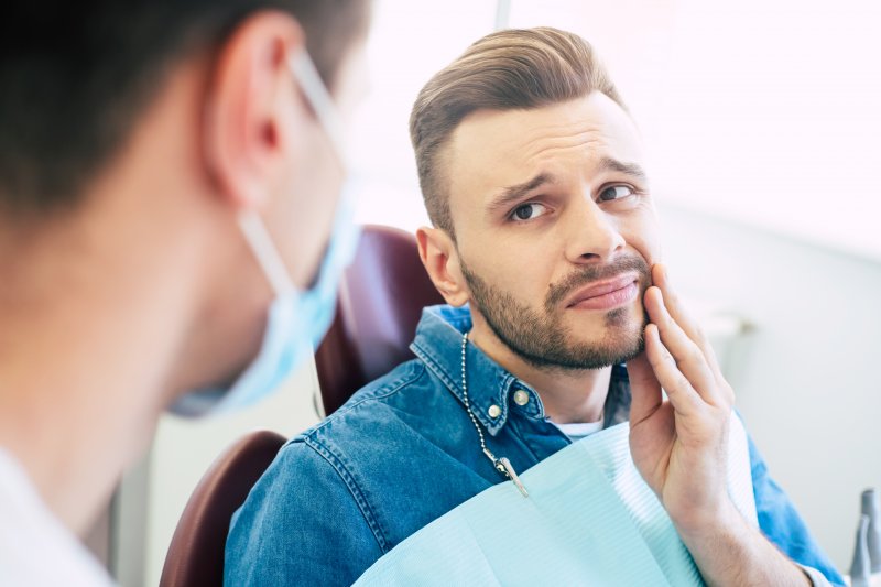 Man talking to dentist about tooth pain