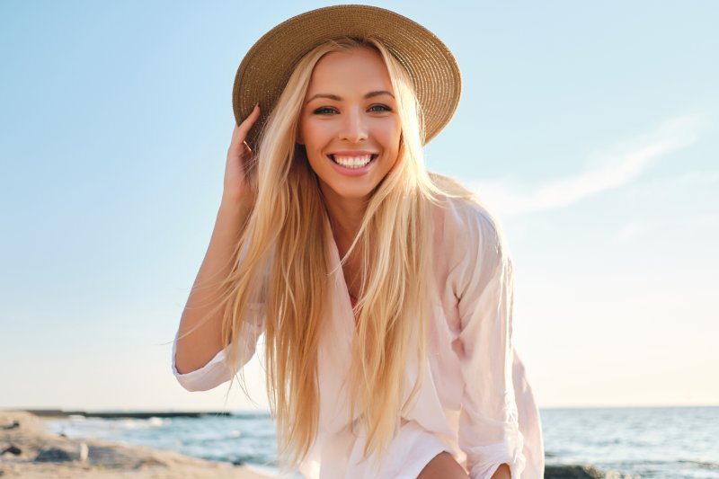 girl with cosmetic treatment smiling on beach