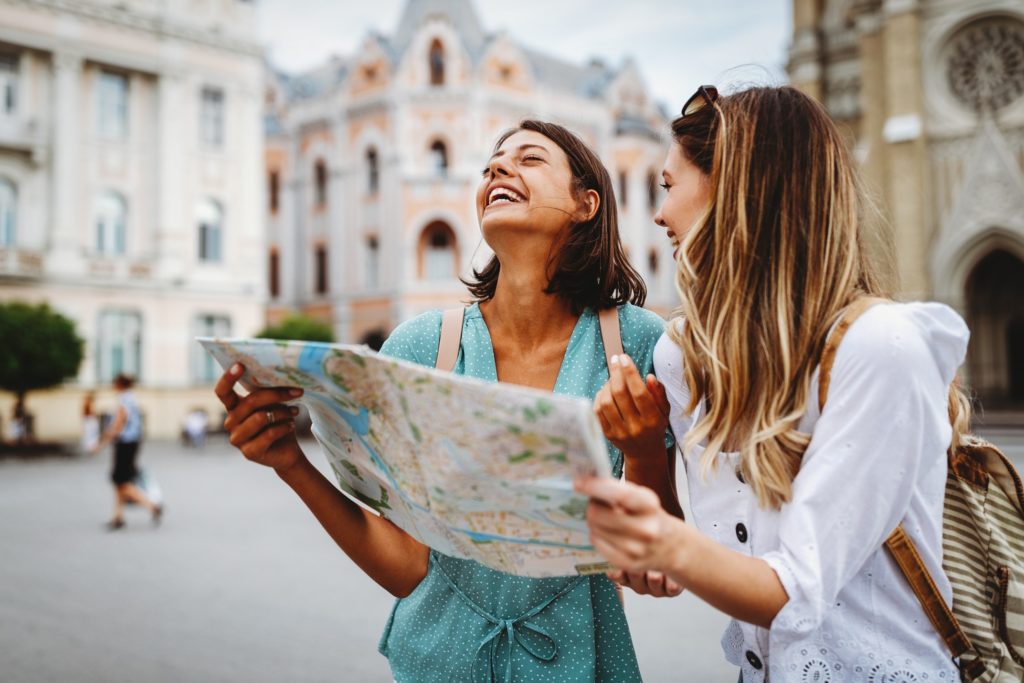 Friends smiling while sightseeing on summer vacation