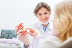 a patient inspecting a denture model 