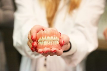 dentist holding out pair of dentures
