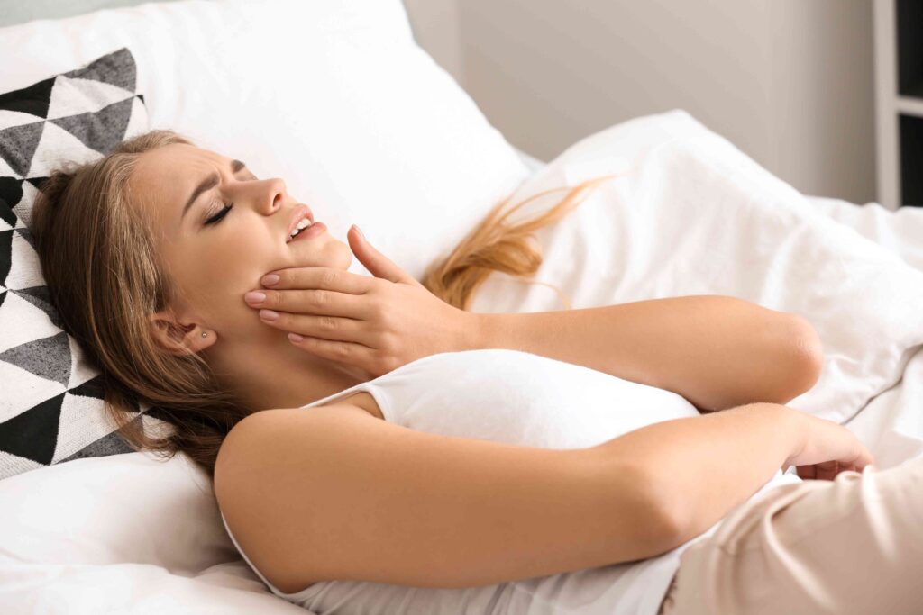 Woman laying in bed with a toothache